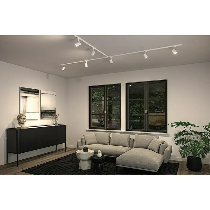 Paulmann URail LED-Spot Luxe - 10 W, Signalweiß, 6,5 x 9 x 16,3 cm - Elegantes Wohnzimmer mit einem modernen Beleuchtungssystem, das aus mehreren weißen Strahlern an einer Schiene unter der Decke besteht. Das System erhellt den Raum.