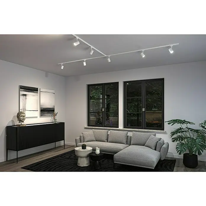 Paulmann URail LED-Spot Luxe - 10 W, Signalweiß, 6,5 x 9 x 16,3 cm, RGBW - Innenaufnahme eines Wohnzimmers mit weißer Schienenbeleuchtung an der Decke. Das Licht beleuchtet elegant den Raum.
