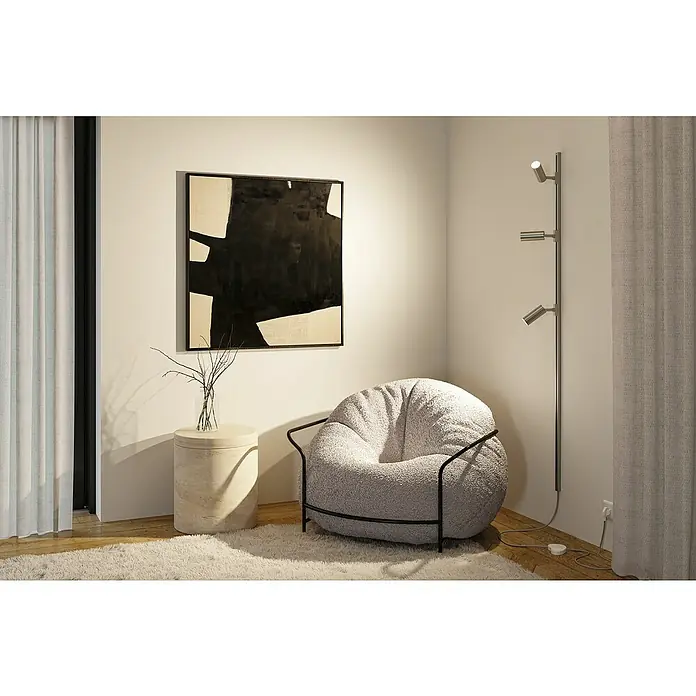 Paulmann URail Stromeinspeisung - Chrom matt, 200 cm - Einladender Lesebereich mit einem flauschigen, runden Sessel mit schwarzem Gestell, einer Stehlampe und einem abstrakten Kunstwerk an der Wand.