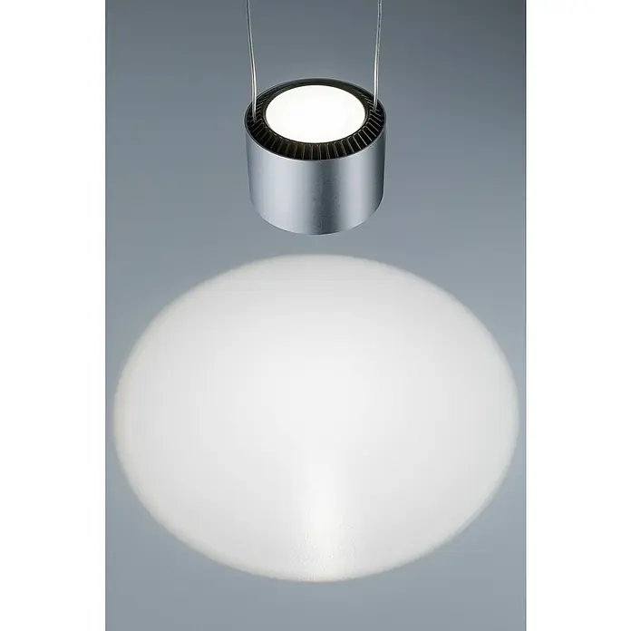 Paulmann URail LED-Pendelleuchte Aldan - Neutralweiß, Chrom matt, Ø x H: 10 x 150 cm, 4.000 K - Nahaufnahme einer modernen, zylindrischen Hängelampe aus Metall, die ein helles, kreisförmiges Licht auf eine graue Oberfläche wirft.