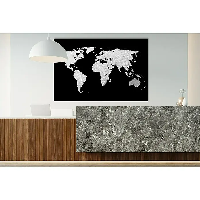 Glasbild - Weltkarte, B x H: 80 x 50 cm - Das auffällige Wandbild einer Weltkarte mit silbernen Kontinenten auf schwarzem Hintergrund, beleuchtet von einer modernen Pendelleuchte.