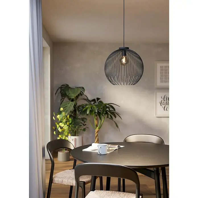 Eglo Venezuela Pendelleuchte rund - 40 W, Ø x H: 40 x 110 cm, Schwarz, Schwarz, E27 - Eine moderne Pendelleuchte mit kugelförmigem, schwarzem Drahtdesign hängt über einem Esstisch mit Stühlen und Pflanzen im Hintergrund.
