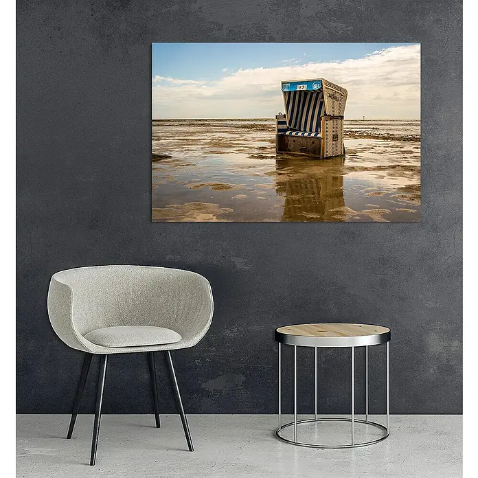 Glasbild - Strandkorb, B x H: 120 x 80 cm - Wandbild mit Strandkorb-Motiv. Der Kunstdruck zeigt einen Strandkorb am Wattenmeer, aufgespannt vor blauem Himmel mit Wolken.