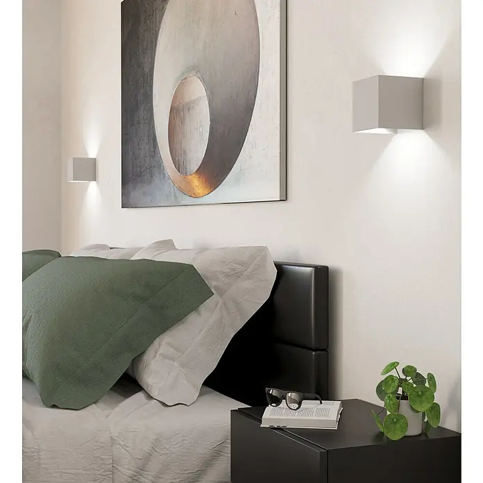 Eglo LED-Wandleuchte Valmontone - 1,5 W, L x B x H: 10 x 10 x 10 cm, Weiß, Warmweiß - Schlafzimmer mit grauen Würfelwandleuchten, abstraktem Bild und Nachttisch mit Brille und Pflanze.