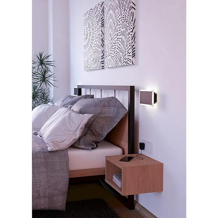 Eglo LED-Wandleuchte Talamello 1 - 12 W, L x B x H: 23 x 5 x 12 cm, Schwarz, Warmweiß - Ein modernes Schlafzimmer mit stilvoller Wandlampe, Nachttisch und dekorativen Kissen. Die Lampe sorgt für angenehmes Licht.