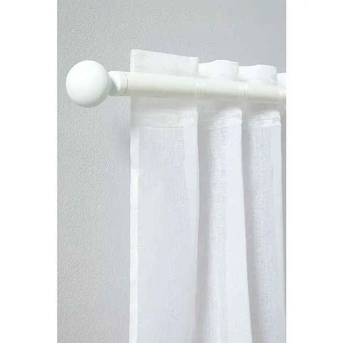 Visillo para ventana Palma - An x Al: 140 x 280 cm, 100% poliéster, Blanco - Primer plano de una barra de cortina blanca con un extremo esférico, que muestra cortinas blancas translúcidas sobre una pared gris.