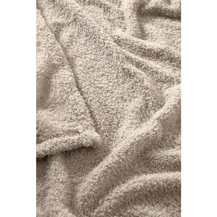 Manta para sofá Oslo - 160 x 220 cm, Poliéster, Beige - Primer plano de una manta beige, suave con textura y pliegues, que evoca calidez y comodidad.