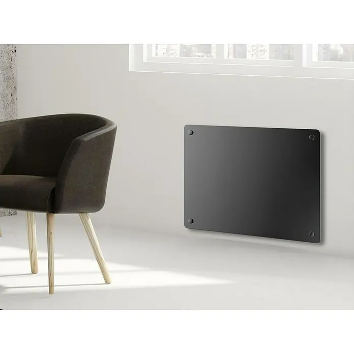 Purline Emisor térmico de cristal - An x Al: 45 x 40 cm, 1.000 W - Un interior moderno con un elegante radiador de panel negro en la pared, junto a una silla elegante y una ventana luminosa.