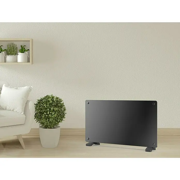 Purline Emisor térmico de cristal - An x Al: 70 x 40 cm, 1.500 W - Un moderno panel de calefacción negro sobre un suelo de madera clara, calentando la estancia con su diseño elegante.