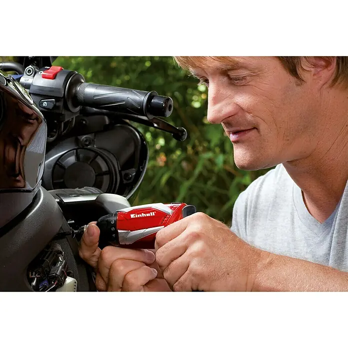 Einhell Akkuschrauber TE-SD 3,6 Li Kit - 3,6 V, 1 Akku, 1,5 Ah - Ein Mann repariert ein Motorrad mit einem roten Einhell Akku-Schraubendreher, der sich durch sein ergonomisches Design auszeichnet.