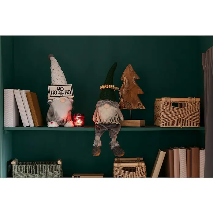 SCHÖNER WOHNEN-Farbe Wandfarbe DesignfarbeBesinnliches Waldgrün, Matt, 1 l, Konservierungsmittelfrei - Weihnachtliche Regaldekoration mit zwei Zwergenfiguren, einem Holzbaum und Bücher. Die gemütliche Atmosphäre wird durch ein rotes Windlicht verstärkt.
