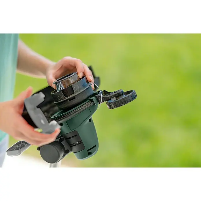 Bosch Ersatzfadenspule - Fadenlänge: 6 m, Fadenstärke: 1,6 mm, Passend für: Bosch Rasentrimmer UniversalGrassCut 18-26 und 18-260 - Eine Person, die eine neue Spule in einem Akku-Rasentrimmer auf einem Rasen installiert.