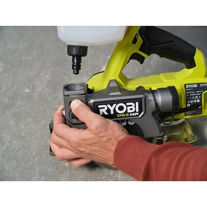 Ryobi Akku-Fliesenschneider RTS18C-0 - 18 V, Ohne Akku - Nahaufnahme einer Ryobi RTS180 Fliesenschneidmaschine mit Kühlmittelbehälter, bedient von einer Hand.