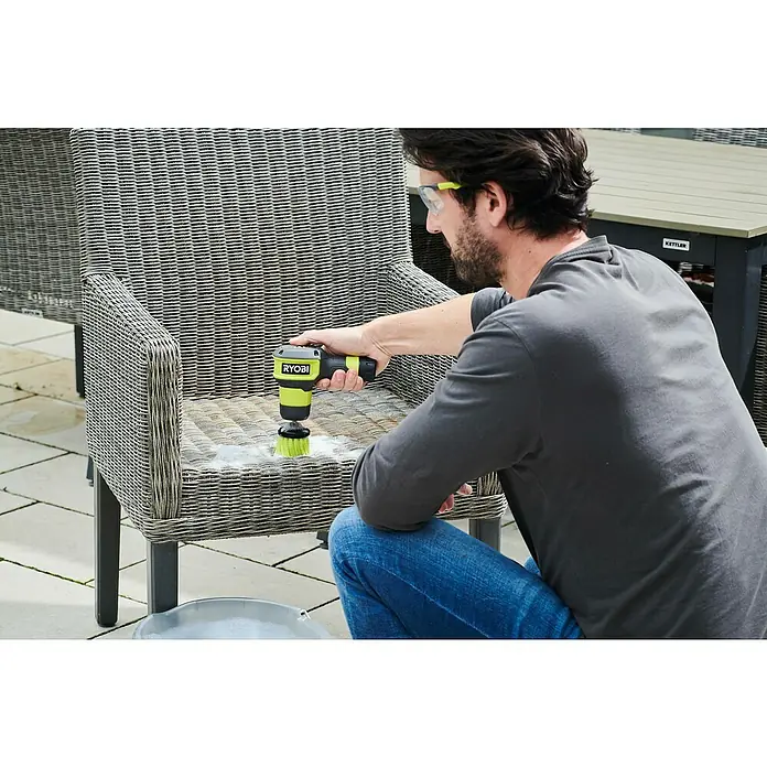 Ryobi 4V USB Akku-Reinigungsbürste RSCR4 - 4 V, 1 Akku, 2 Ah - Mann reinigt einen Rattansessel mit einer RYOBI-Elektrobürste, um ihn sauber und neuwertig zu halten.