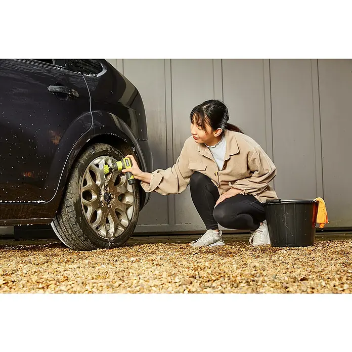 Ryobi 4V USB Akku-Reinigungsbürste RSCR4 - 4 V, 1 Akku, 2 Ah - Eine Frau putzt mit einem Ryobi-Akku-Scheuergerät ein Autorad. Ideal zum Reinigen von Felgen und schwer zugänglichen Stellen am Auto.