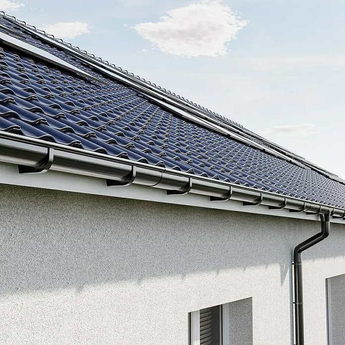 Marley Dachrinne - Nennweite: 125 mm, Länge: 100 cm, Kunststoff, Anthrazit - Nahaufnahme eines modernen Hauses mit eleganten schwarzen Dachziegeln und einer passenden Dachrinne, die das architektonische Design hervorhebt.