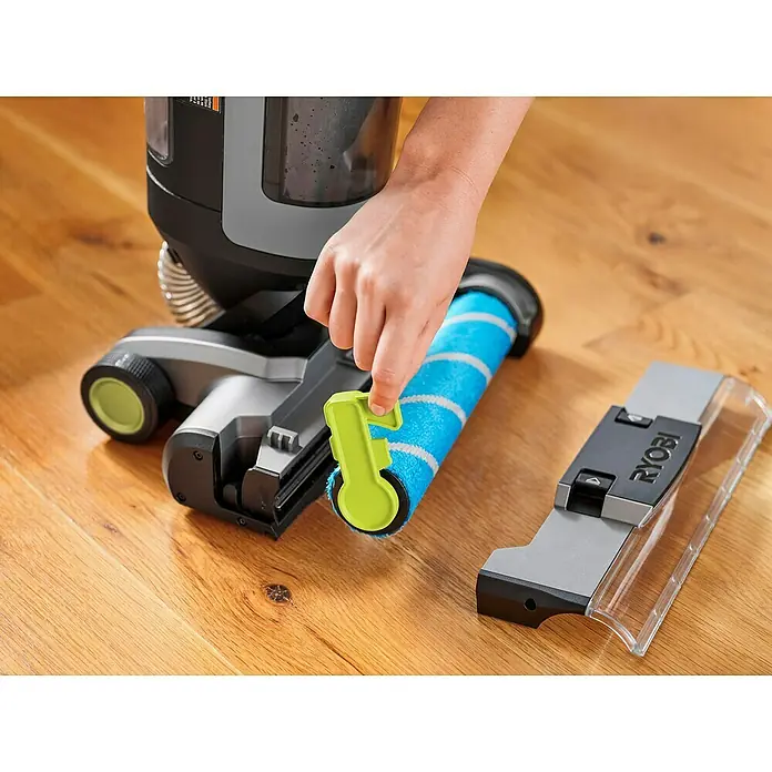 Ryobi Universalwalze RHFCR - Passend für: Ryobi Akku-Hartbodenreiniger RHFC18BL-0 - Detailaufnahme einer Person, die eine blaue Reinigungsbürste des Ryobi-Staubsaugers mit grünem Zubehörteil in der Hand hält.