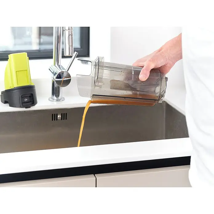 Ryobi ONE+ Akku-Hartbodenreiniger RHFC18BL-0 - 18 V, Ohne Akku, Luftmenge: 710 l/min - Eine Person leert einen transparenten Behälter mit schmutzigem Wasser in ein Spülbecken, wobei der Fokus auf dem Entleeren des Behälters liegt.