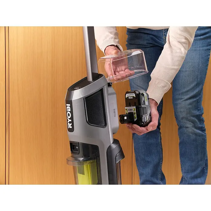 Ryobi ONE+ Akku-Hartbodenreiniger RHFC18BL-0 - 18 V, Ohne Akku, Luftmenge: 710 l/min - Ein Mann wechselt den Akku an einem grauen Ryobi Akku-Staubsauger. Der Akku ist schwarz und hat die Aufschrift "Ryobi 18V".