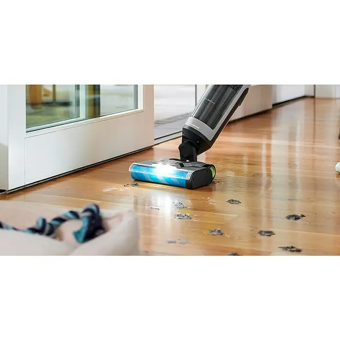 Ryobi ONE+ Akku-Hartbodenreiniger RHFC18BL-0 - 18 V, Ohne Akku, Luftmenge: 710 l/min - Ein kabelloser Staubsauger entfernt Schmutz von einem Holzboden, was die Reinigungsleistung und den Komfort des Geräts hervorhebt.