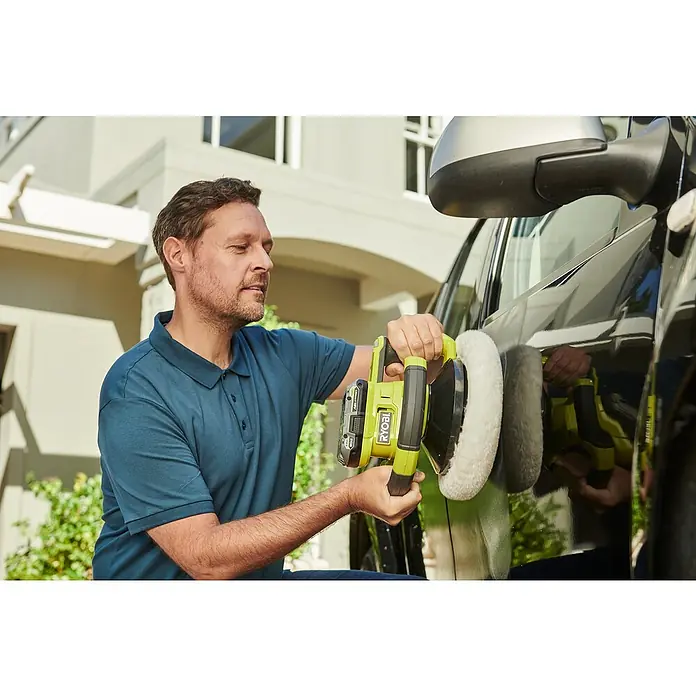 Ryobi ONE+ Poliermaschine RBP18250-0 - 18 V, Ohne Akku, Leerlaufdrehzahl: 2.000 U/min - 3.600 U/min - Ein Mann poliert ein schwarzes Auto mit einer grünen Ryobi Poliermaschine für ein glänzendes Finish.