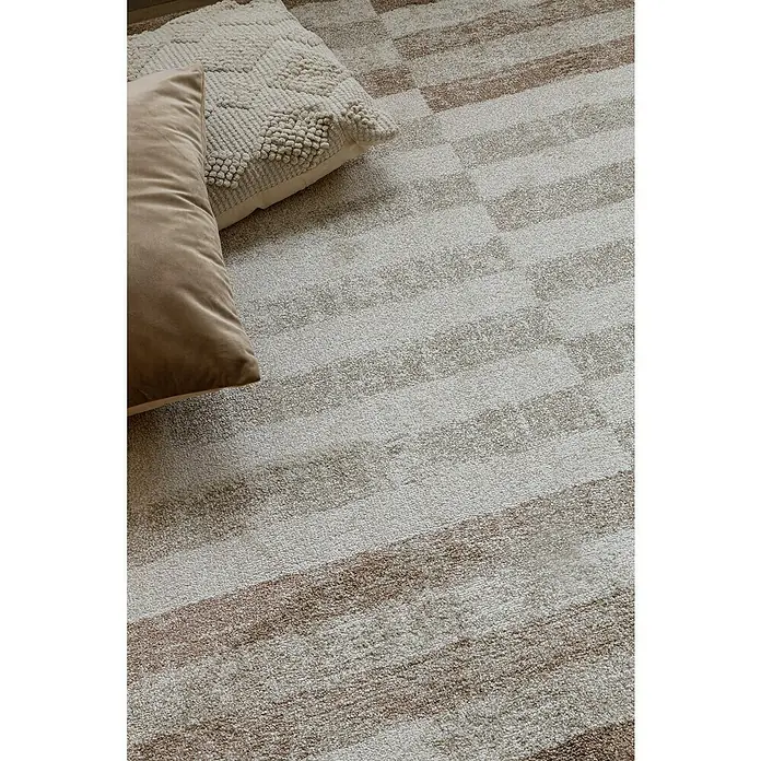 Cojín Velvet - 45 x 45 cm, Textil, Topo - Primer plano de una alfombra con un patrón de rayas horizontales y dos cojines, creando un ambiente acogedor.