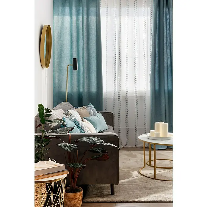 Espejo de pared Gia con marco - Diámetro: 60 cm, Oro - Elegante salón con cortinas azules y blancas que añaden un ambiente tranquilo a la habitación mientras filtran la luz natural.