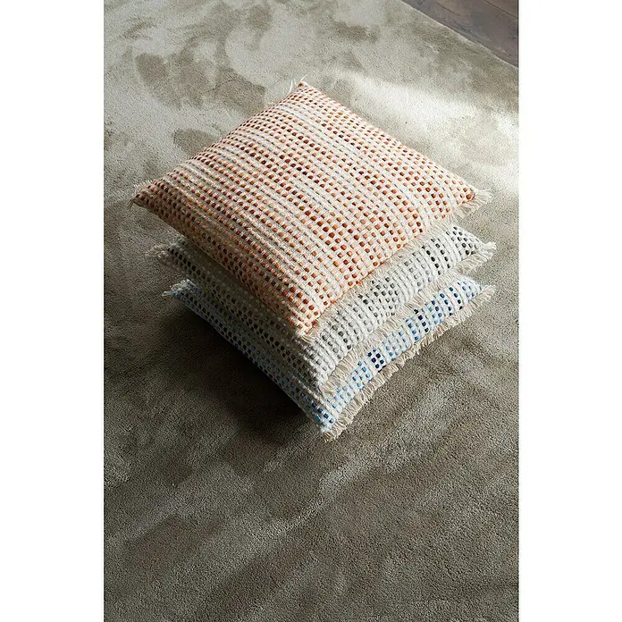 Cojín Dakira - 45 x 45 cm, Textil, Natural, Cuadrado - Tres elegantes cojines cuadrados con borlas apilados uno encima del otro, con el cojín superior en naranja.