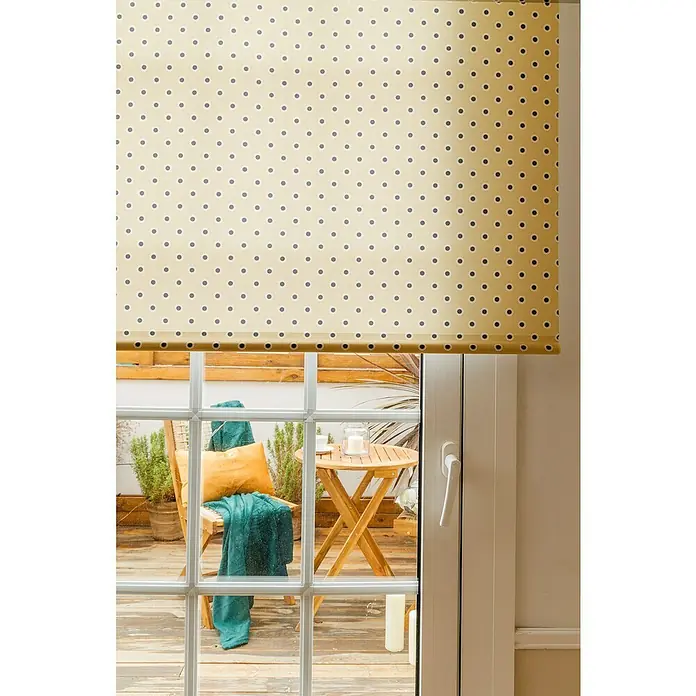 Cojín Velvet - 30 x 50 cm, Textil, Yema, Rectangular - Persiana enrollable beige con puntos negros delante de una puerta de patio. La persiana proporciona privacidad y luz.