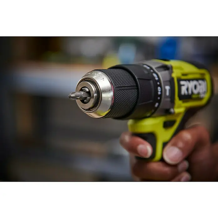 Ryobi ONE+ Akku-Schlagbohrschrauber RPD18C1-0 C - 18 V, Ohne Akku, 60 Nm - Nahaufnahme eines Ryobi Akku-Bohrschraubers mit eingesetztem Bit, gehalten von einer Person. Das Gerät ist gelb und schwarz, mit deutlichem Markenlogo.