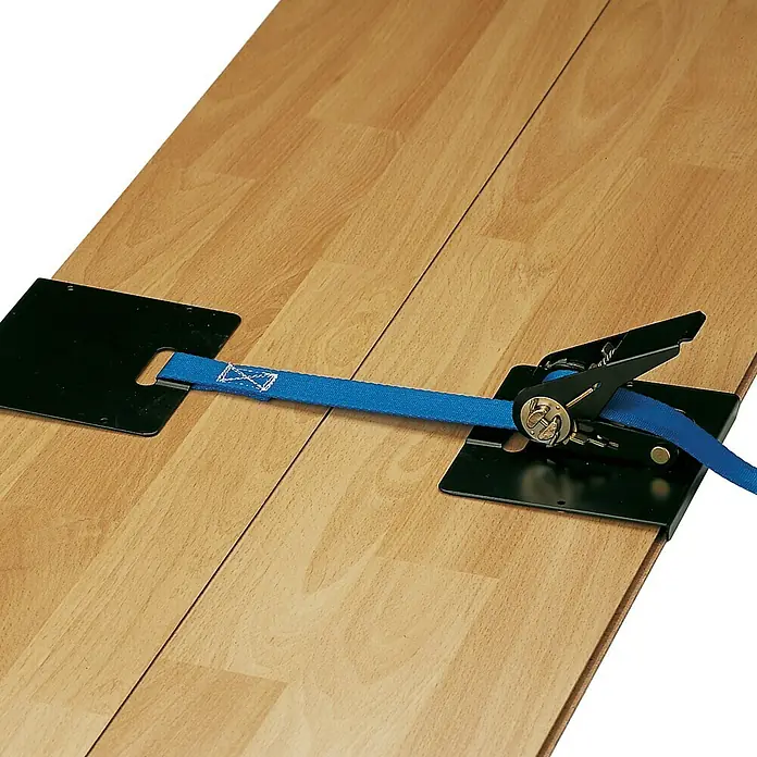 Piher Herramienta para la colocación de suelos de madera 30014 - Largo: 5 m - Herramienta de sujeción asegurada sobre piso laminado marrón claro con una correa de cinta azul para mantener los paneles en su lugar.