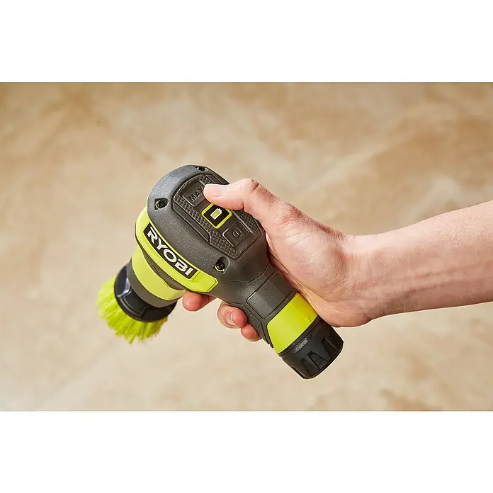 Ryobi 4V USB Akku-Reinigungsbürste RSCR4 - 4 V, Ohne Akku - Nahaufnahme einer Hand, die einen gelben und grauen Akku-betriebenen RYOBI-Reinigungsschrubber vor einem beigen Hintergrund hält.