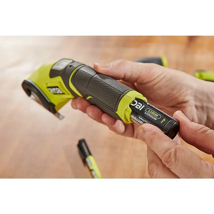 Ryobi 4V USB Akku-Universalschere RCT4-0 - 4 V, Ohne Akku - Nahaufnahme eines Ryobi-Werkzeugs mit einem Akku, das die Vielseitigkeit und das innovative Design für Heimwerkerarbeiten hervorhebt.