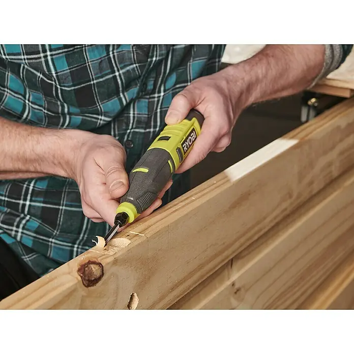Ryobi 4V USB Akku-Schnitzer RPC4-0 - 4 V, Ohne Akku - Ein gelb-schwarzer Ryobi-Elektroschaber wird verwendet, um Holz zu bearbeiten und Splitter zu entfernen. Ideal für detaillierte Holzarbeiten.