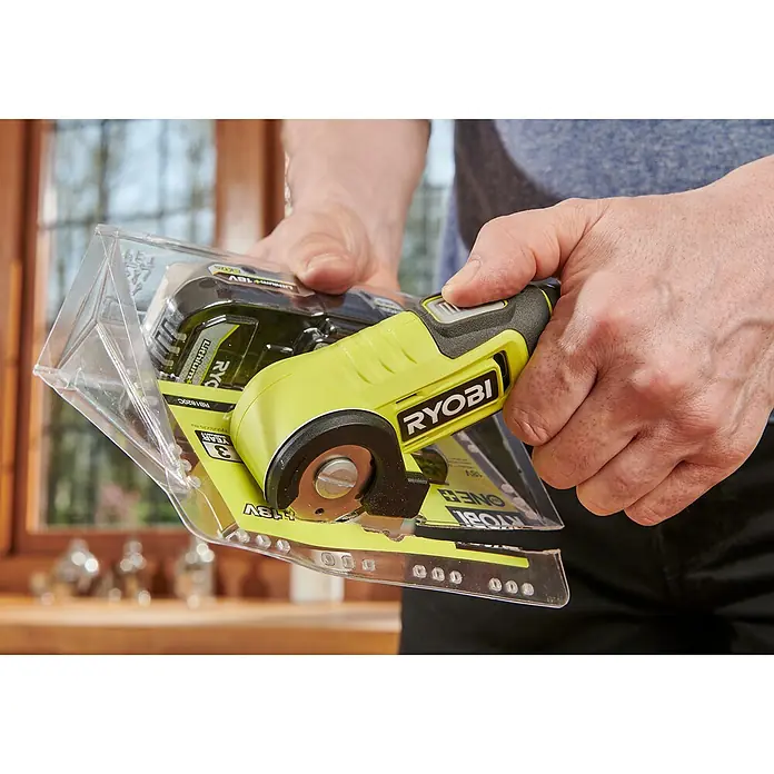 Ryobi 4V USB Akku-Universalschere RCT4-0 - 4 V, Ohne Akku - Nahaufnahme eines Ryobi-Rotationsschneiders in einer transparenten Verpackung, der in der Hand gehalten wird.