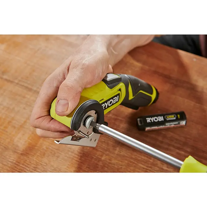 Ryobi 4V USB Akku-Universalschere RCT4-0 - 4 V, Ohne Akku - Ein Ryobi P4360 One+ Akku-Rotationsschneider wird mit einem Schraubendreher auf einem Holztisch justiert.
