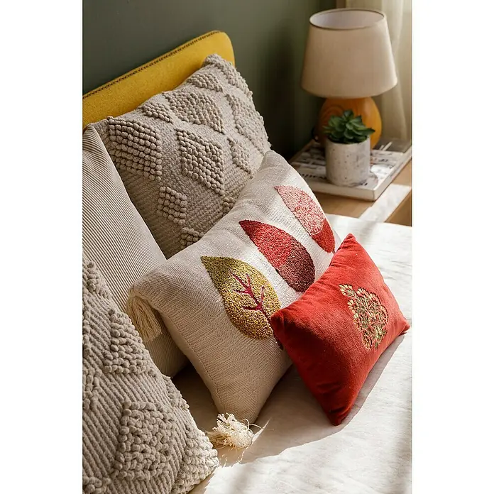 Cojín Pana - 45 x 45 cm, Poliéster, Crudo, Cuadrado - Primer plano de cojines decorativos con motivos de otoño y texturas sobre una cama.