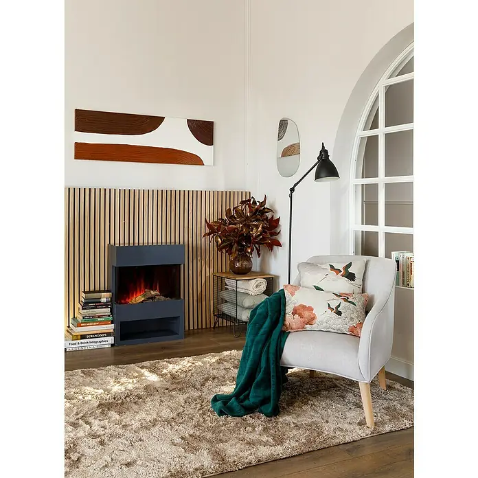 Panel de pared Linari - 120 x 50 cm, 2 ud. - Salón con sillón gris, chimenea y alfombra acogedora. El diseño interior irradia un ambiente agradable y hogareño.