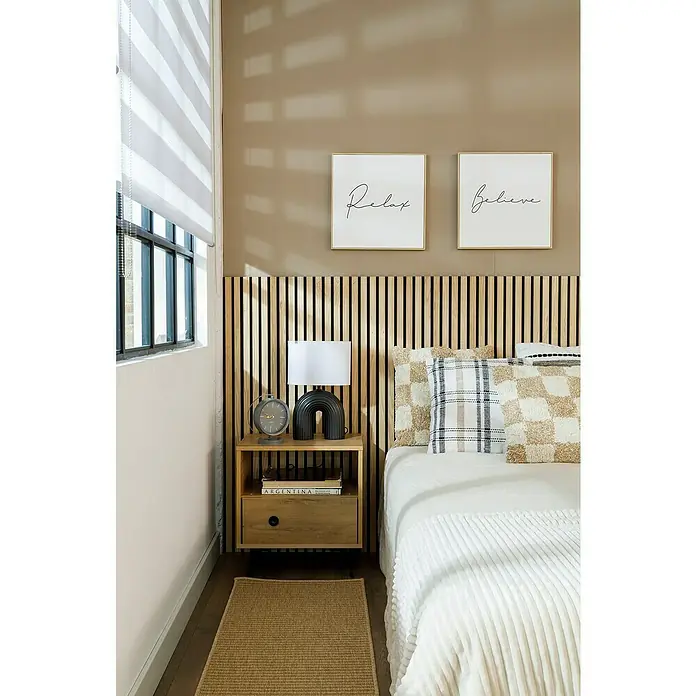 Panel de pared Linari - 120 x 50 cm, 2 ud. - Dormitorio acogedor con cabecero de madera, mesita de noche con lámpara y decoración, y dos láminas enmarcadas con "Relax" y "Believe".
