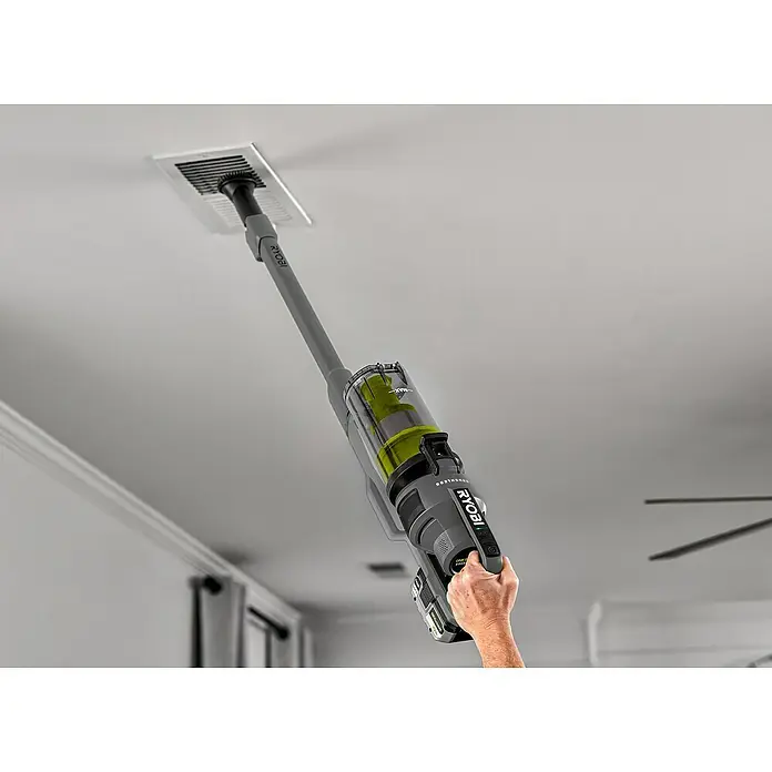 Ryobi ONE+ Akku-Staubsauger RSV18BL - 18 V, 1 Akku, 4 Ah, Behältervolumen: 0,8 l - Ein Ryobi Akku-Staubsauger wird verwendet, um einen Deckenlüftungsschacht zu reinigen. Das Gerät ist grau und hat einen durchsichtigen Behälter.