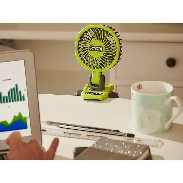 Ryobi 4V USB Akku-Ventilator RCF4-120G - 4 V, 1 Akku - Ein grüner, tragbarer Ryobi-Ventilator, der an einem Schreibtisch befestigt ist, sorgt für eine kühle Brise bei der Arbeit. Ideal für heiße Tage im Büro.
