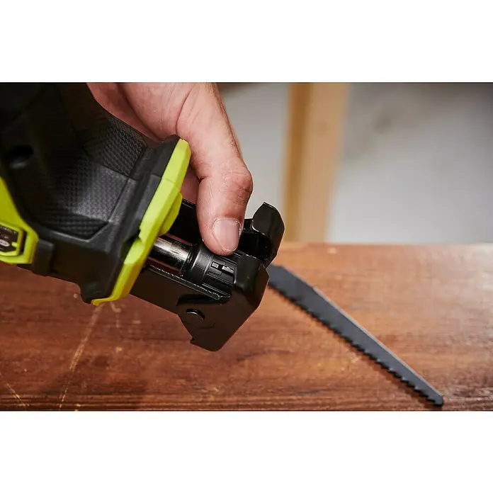 Ryobi ONE+HP Akku-Säbelsäge RRS18C1-0 - 18 V, Leerlaufdrehzahl: 0 U/min - 3.200 U/min, Hublänge: 23 mm - Detailaufnahme einer Ryobi Säbelsäge beim Sägeblattwechsel, Fokus auf Mechanismus und Hand.