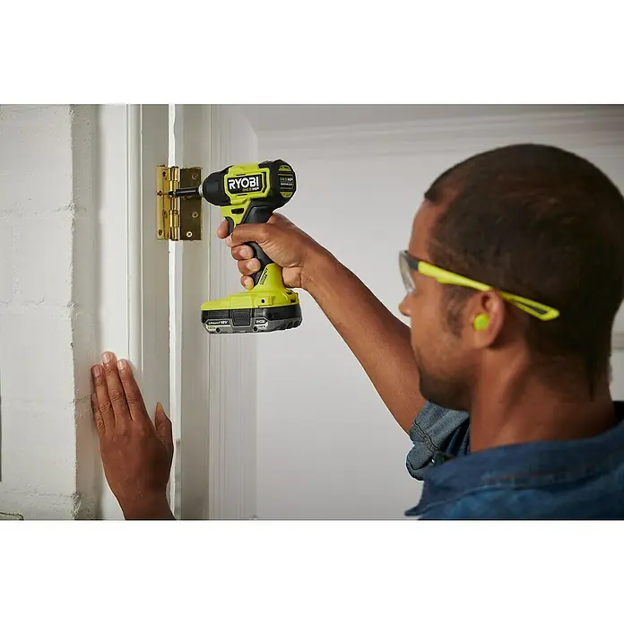 Ryobi ONE+HP Akku-Schlagschrauber RID18C1-0 - 18 V, Ohne Akku, 240 Nm - Ein Mann benutzt einen Ryobi ONE+ HP Akku-Schlagschrauber, um ein Scharnier an einer Tür zu befestigen.