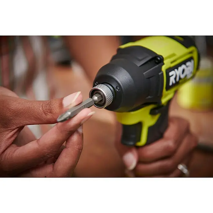 Ryobi ONE+HP Akku-Schlagschrauber RID18C1-0 - 18 V, Ohne Akku, 240 Nm - Eine Person wechselt den Bohrer an einem gelben und schwarzen Ryobi-Schlagschrauber, um sich auf die Arbeit vorzubereiten.