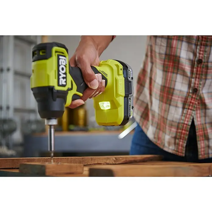 Ryobi ONE+HP Akku-Schlagschrauber RID18C1-0 - 18 V, Ohne Akku, 240 Nm - Der Ryobi Akku-Schlagschrauber wird beim Arbeiten in Holz gezeigt, die LED leuchtet für eine bessere Sicht.