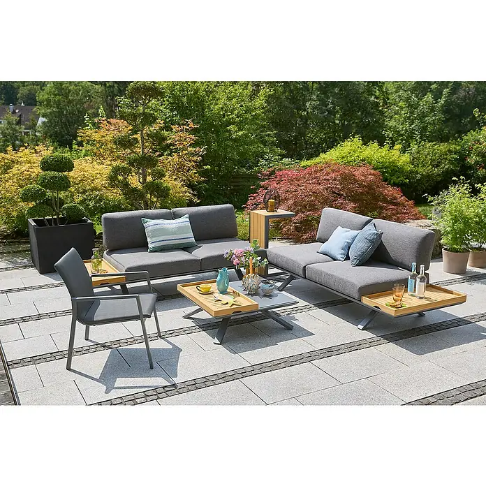 Sunfun Loungemöbel-Set Lumar/Solo - 8 -tlg., Aluminium, Teak, Night-Grey - Elegante graue Gartenmöbel-Lounge mit Tisch und Stuhl auf einer Terrasse, umgeben von üppigem Grün. Ideal für entspannte Stunden im Freien.