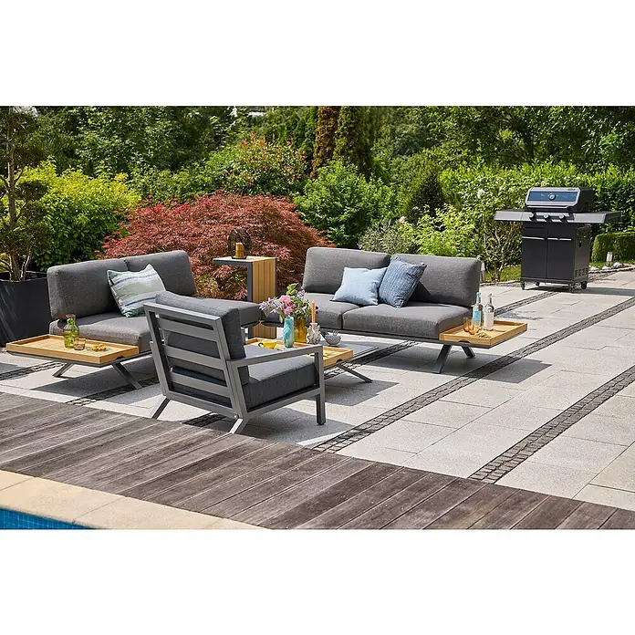 Kingstone KMS Gasgrill Cliff 3000 Beast Black Edition - Grillfläche (B x T): 61 x 45 cm, 10,5 kW, Anzahl Brenner: 3 Stk. - Einladende Outdoor-Lounge-Gruppe mit grauen Sofas und Sesseln, ergänzt durch stilvolle Beistelltische und einen Grill im Hintergrund.