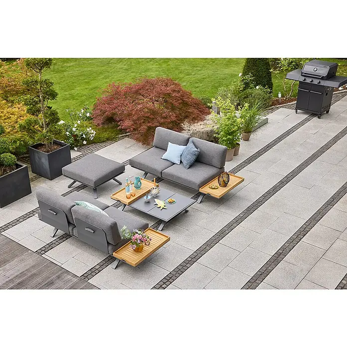 Sunfun Lumar Garten-Couchtisch - L x B x H: 120 x 80 x 27 cm, Aluminium, Night-Grey - Gartenmöbel-Set auf einer Terrasse mit grauem Sofa, Sesseln, Tisch und Beistelltischen aus Holz, umgeben von Grün.