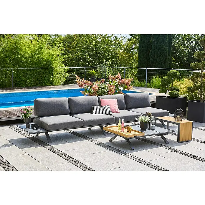 Sunfun Loungemöbel-Set Lumar/Solo - 5 -tlg., Aluminium, Teak, Night-Grey - Eine graue Gartenlounge-Gruppe mit Couchtisch und Beistelltisch auf einer Terrasse mit Pool im Hintergrund.