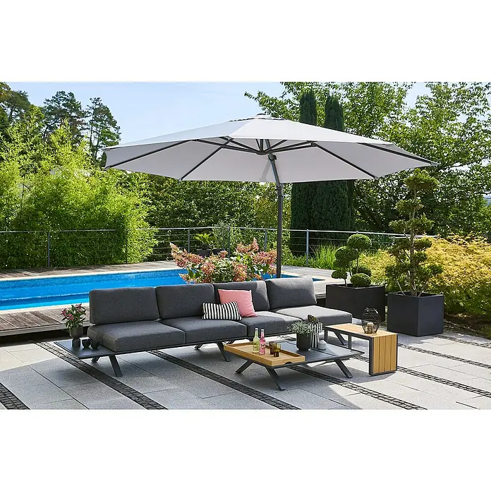 Sunfun Loungemöbel-Set Lumar/Solo/Capri - 6 -tlg., Aluminium, Teak, Night-Grey - Eine graue Gartenlounge mit Sonnenschirm, Couchtisch und Dekoration auf einer gepflasterten Terrasse neben einem Pool, umgeben von Grün.